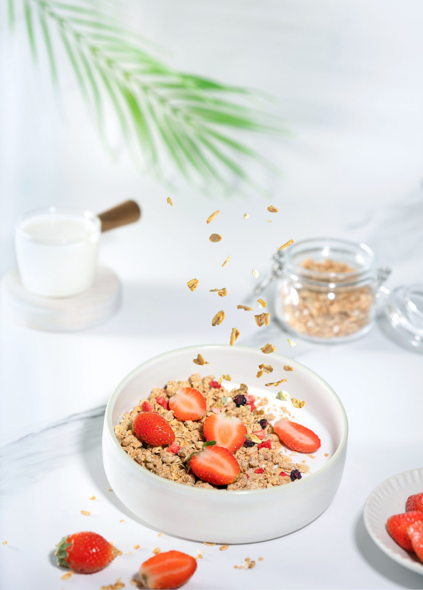 Granola with yogurt and strawberry for healthy breakfast on a white marble table